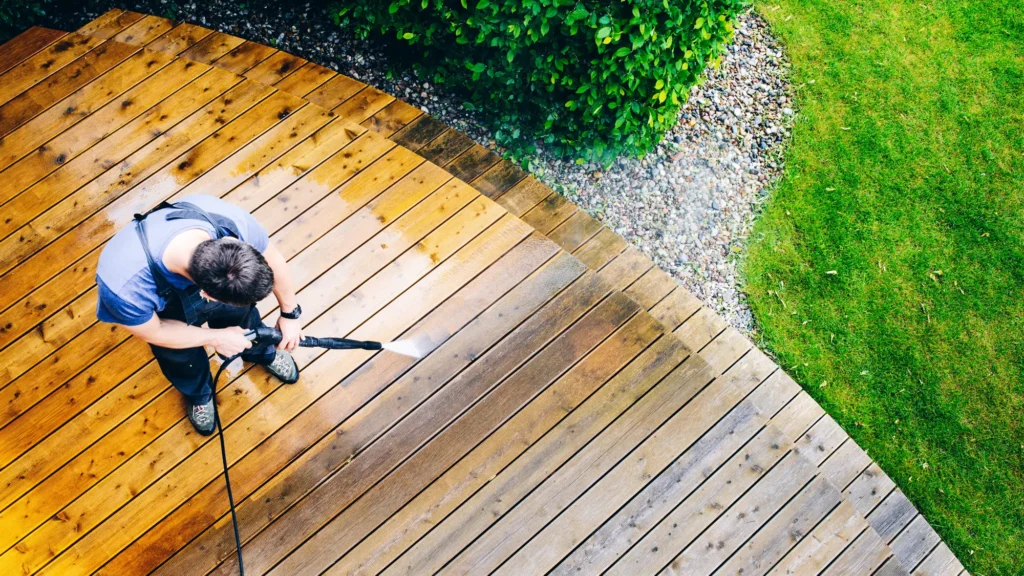 H2pro using power washing to clean the deck on the exterior of a home